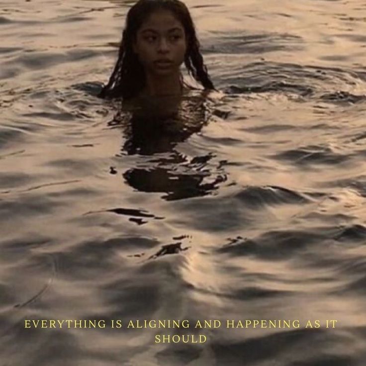 a woman is swimming in the water with her head above the water