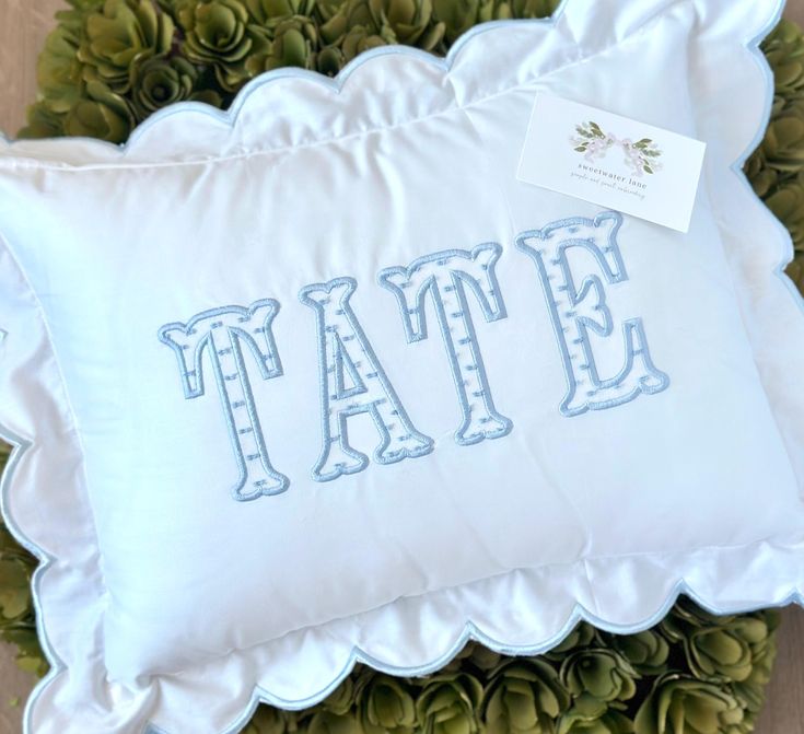 a white pillow with the word tate on it