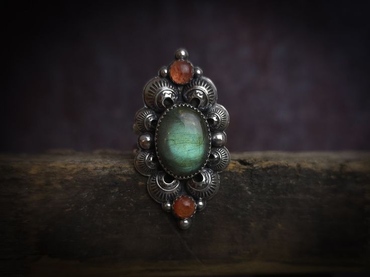 This ring is one of a kind, fabricated in my home studio of sterling and fine silver.  SIZE: 11 US, it cannot be resized  GEMSTONES: Sunstone & labradorite  METAL: Sterling and fine silver Please message me if you have any questions. Thanks for shopping in my little storefront!  -Farrah, silversmith and owner of Arachne Jewels  I weild a lot of mighty tools, but none can force a delayed package along any faster. Shipping delays are uncommon, but do happen (on the part of USPS or other carrier se Artisan Multi-stone Ring Jewelry, Artisan Multi-stone Ring, Unique Sterling Silver Moonstone Ring, Artisan Moonstone Ring For Healing, Handmade Vintage Sterling Silver Moonstone Ring, Artisan Moonstone Ring, Artisan Oval Moonstone Ring, Artisan Moonstone Anniversary Ring, Unique Untreated Ring Jewelry