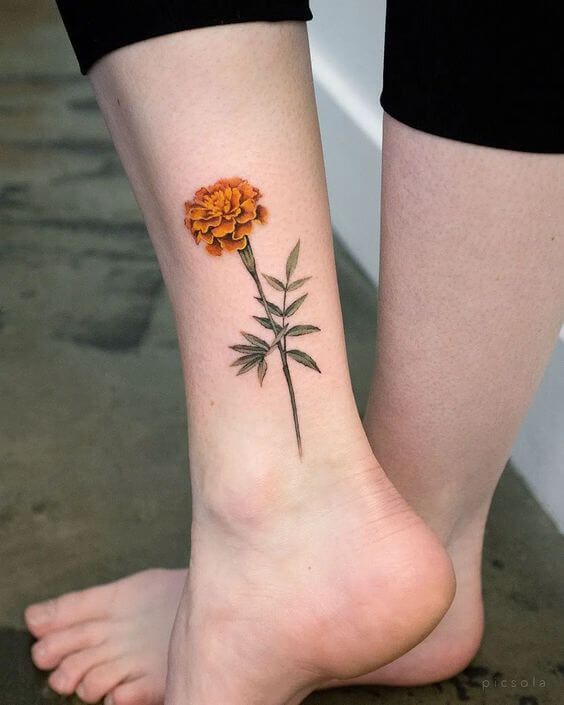 a woman's foot with an orange flower tattoo on her left side calfocks