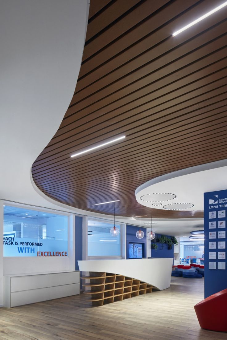 the interior of an office building with wood floors and curved ceiling, along with large windows