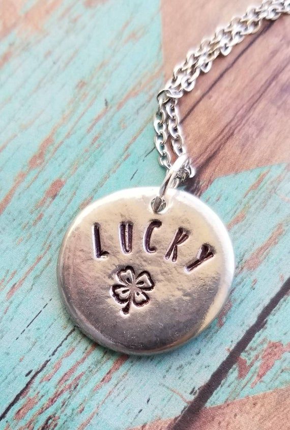 You are one of kind, let your jewelry be the same!These hand formed 7/8 inch pewter pebbles are each totally unique are stamped with "lucky" and a 4 leaf clover.  These necklaces make great and beautiful statements.  Smooth lead free pewter also serves as a great worry stone!.*all items are made to order, colors, fonts and designs may vary. If you want something specific please message me prior to purchase. Silver Hand Stamped Meaningful Charm Necklace, Meaningful Hand Stamped Sterling Silver Charm Necklaces, Meaningful Hand Stamped Sterling Silver Charm Necklace, Adjustable Stamped Sterling Silver Charm Necklaces, Adjustable Sterling Silver Stamped Charm Necklace, Stamped Sterling Silver Round Disc Charm Necklace, Sterling Silver Stamped Round Disc Charm Necklace, Good Luck Silver Engraved Charm Necklaces, Personalized Sterling Silver Charm Necklace For Good Luck