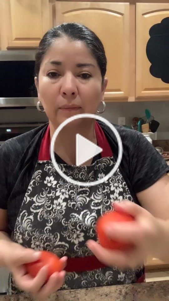 a woman holding two tomatoes in her hands