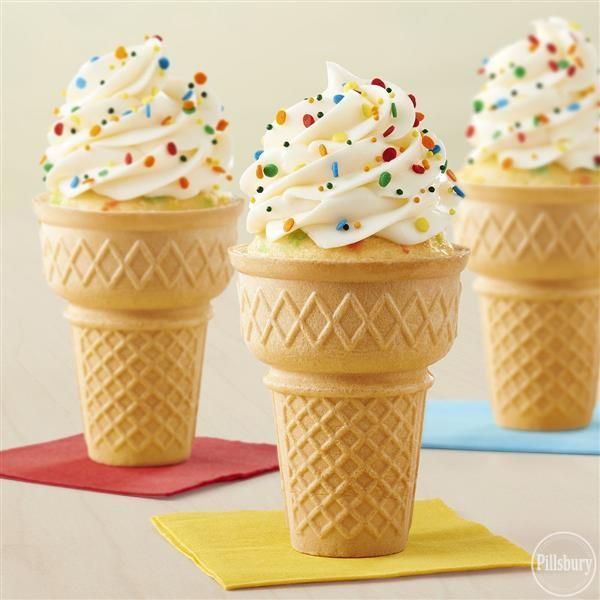 three ice cream cones with sprinkles and colored paper napkins on a table