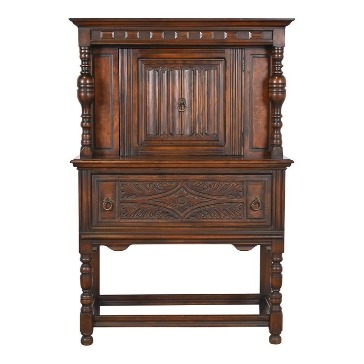 an old wooden cabinet with carvings on the front and sides, against a white background