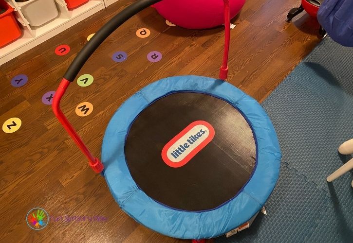 a child's gym equipment sits on the floor in a playroom with toys