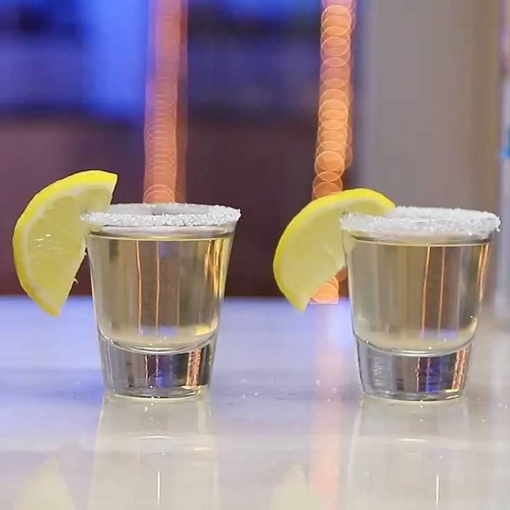 two shot glasses filled with ice and lemon slices