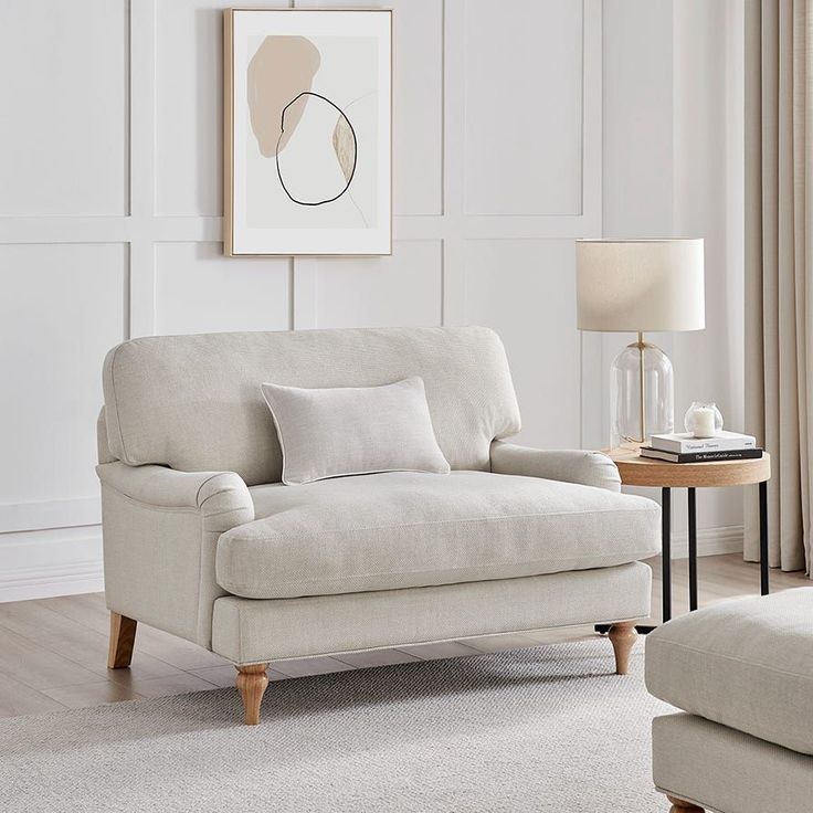 a living room with a couch, chair and coffee table in front of a white wall