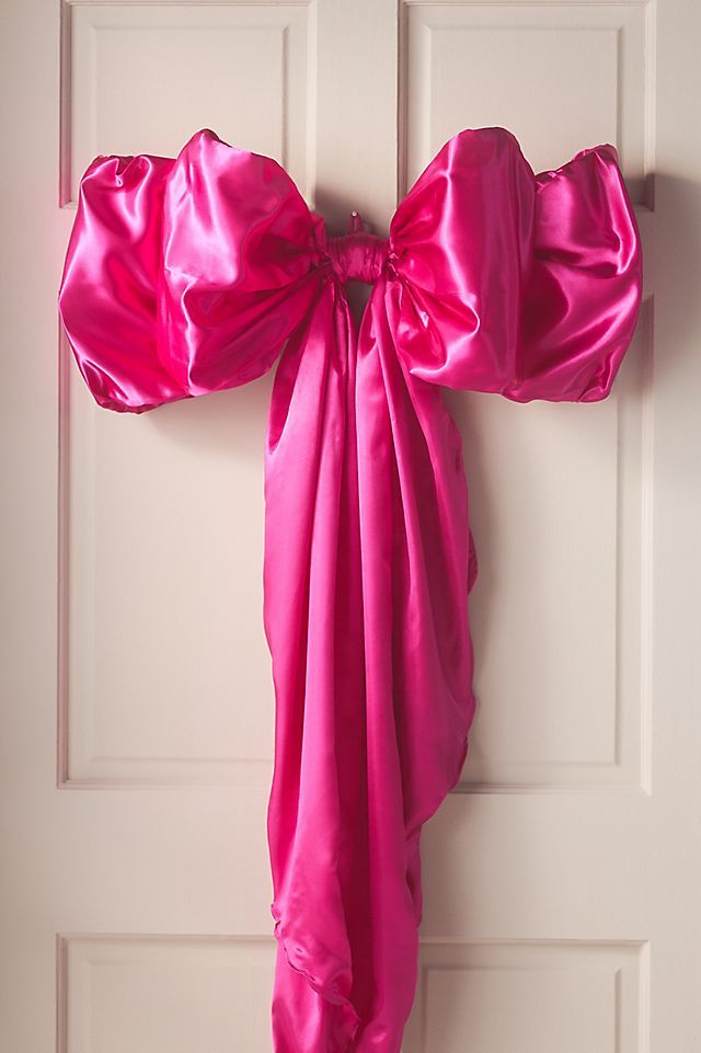 a pink bow hangs on the front door