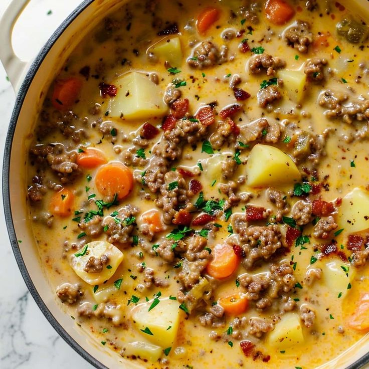 a pot filled with meat and potatoes on top of a table