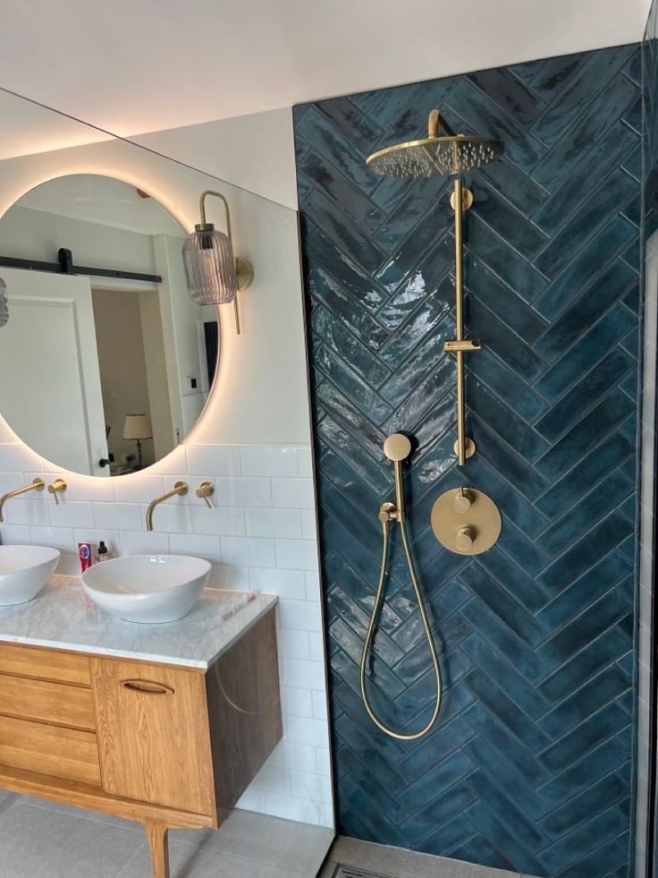 a bathroom with two sinks and a shower head in the corner, along with a mirror on the wall