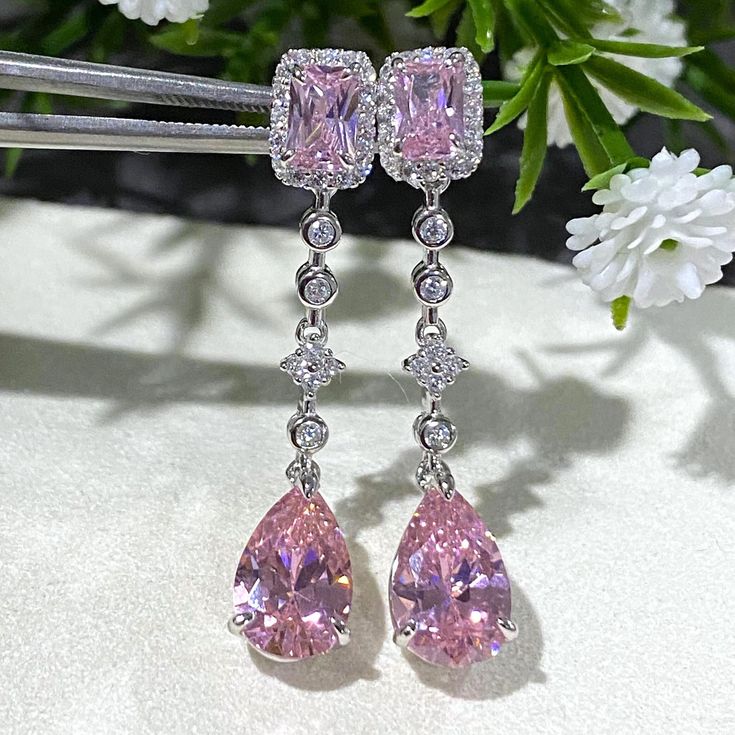 These exquisite vintage dangle earrings feature vibrant pink sapphires surrounded by sparkling white topaz stones, all set in sterling silver (marked 925). The combination of the colorful gemstones and shimmering silver gives these earrings a timeless, elegant appeal. Details: Total Weight: 4.8 grams Measurements: Height: 1 1/2" | Width: 2/8" Material: Sterling Silver (marked 925) Condition: Very good, with minimal signs of wear consistent with age. These earrings are perfect for special occasio Pink Diamond Teardrop Earrings, Pink Diamond Earrings With Diamond Accents, Pink Teardrop Diamond Earrings, Pink Diamond Accent Earrings For Gifts, Pink Earrings With Diamond Accents For Gift, Pink Earrings With Diamond Accents As A Gift, Sparkling Pink Cubic Zirconia Earrings, Pink Sparkling Cubic Zirconia Earrings, Fine Jewelry Pink Earrings With Sparkling Stones