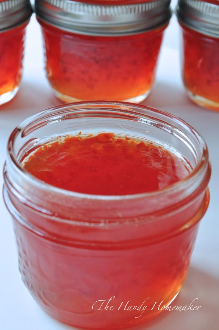 jars filled with red liquid sitting on top of a table