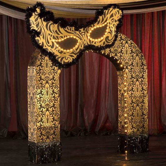 an elaborately decorated archway in the middle of a stage with red curtains behind it