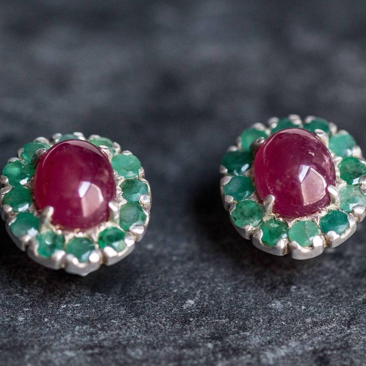 Victorian Emerald Earrings set with a Natural Emeralds in a diamond cut at 3mm each. With Natural Ruby set in the center in a stunning smooth quality, at 10x8mm each (6 Cts pair) from Burma.Solid 925 Sterling Silver ☞ made to last.Click here for ☞ Matching RingClick here for ☞ Matching PendantDetails:• Natural Ruby (Burma), Natural Emerald (Colombia)• Ruby: 10x8mm each, 6 Cts a pair, cabochon cut• Emeralds: 3mm each, 3 Ct a pair, diamond cut• Lever Back Closure - "English Lock"• Dimensions: Leng Round Multi-stone Earrings For Anniversary, White Gold Multi-stone Round Earrings, Anniversary Multi-stone Round Earrings, Anniversary Multi-stone Earrings, Fine Jewelry Cluster Gemstone Earrings, Fine Jewelry Gemstone Cluster Earrings, Fine Gemstone Cluster Earrings, Sterling Silver Cluster Jewelry With Matching Earrings, Round Gemstone Clip-on Earrings For Anniversary