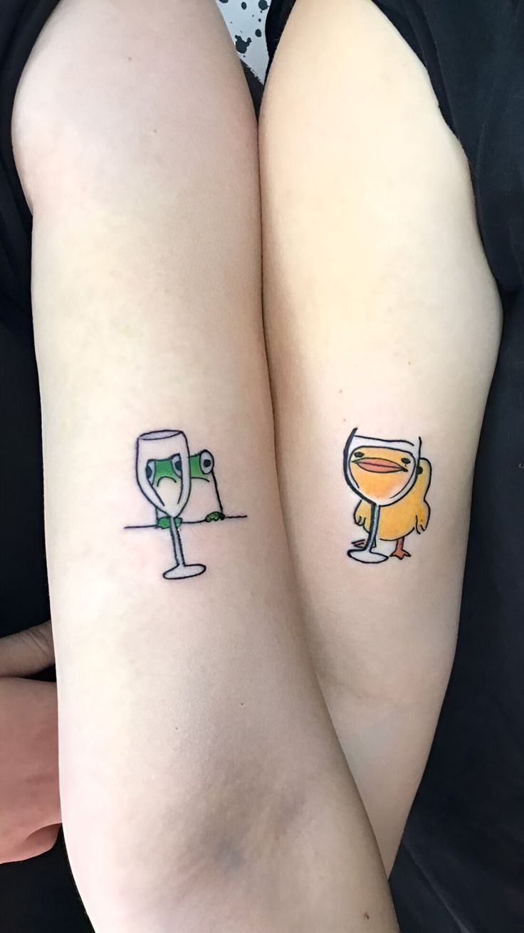 two people with matching tattoos on their arms, one has a glass and the other has a wine glass