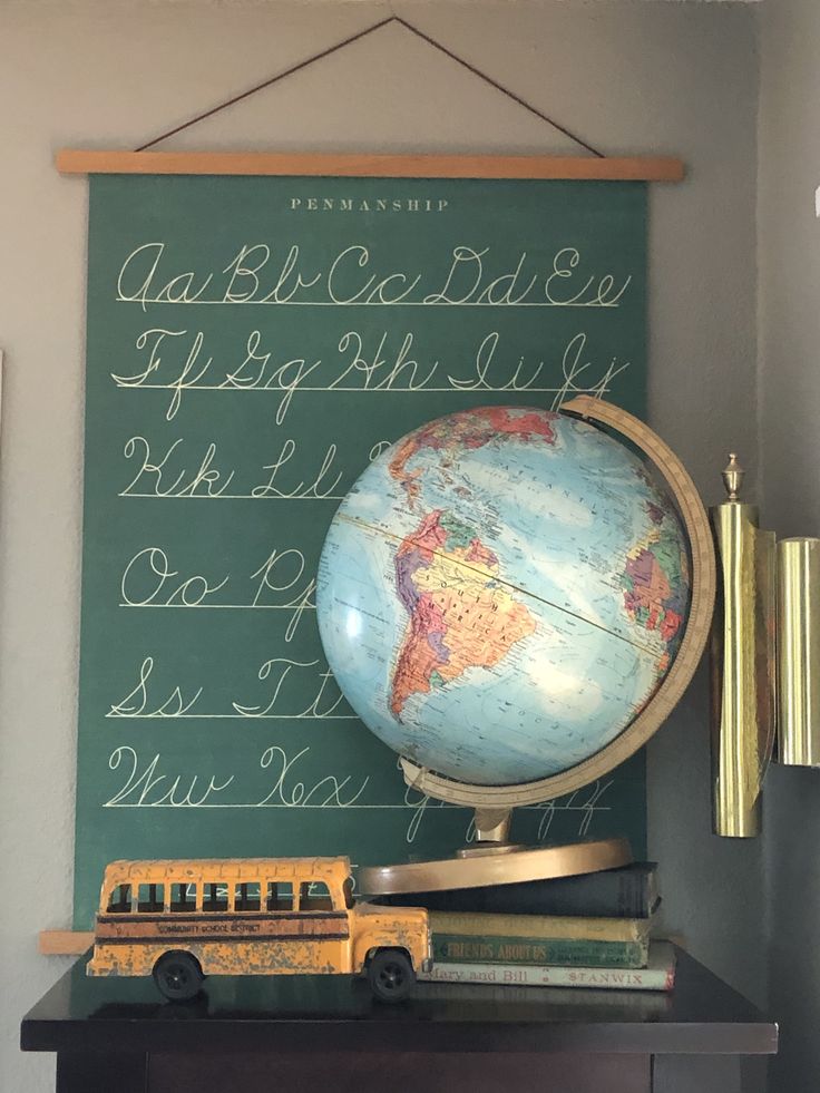 an old school desk with a globe and books on it