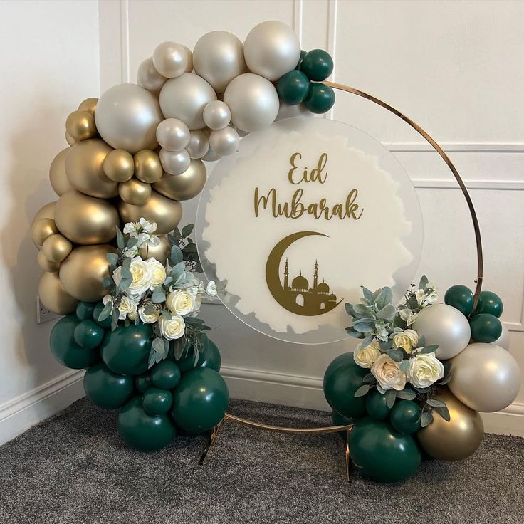 balloons and flowers are arranged in front of an eid mubarak sign