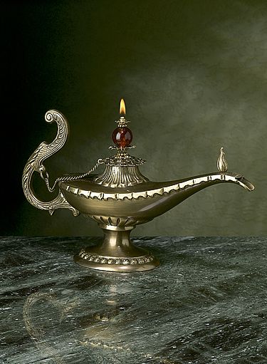 an ornate metal bowl with a candle on it