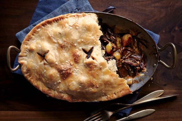 a pie sitting on top of a table next to utensils and a fork