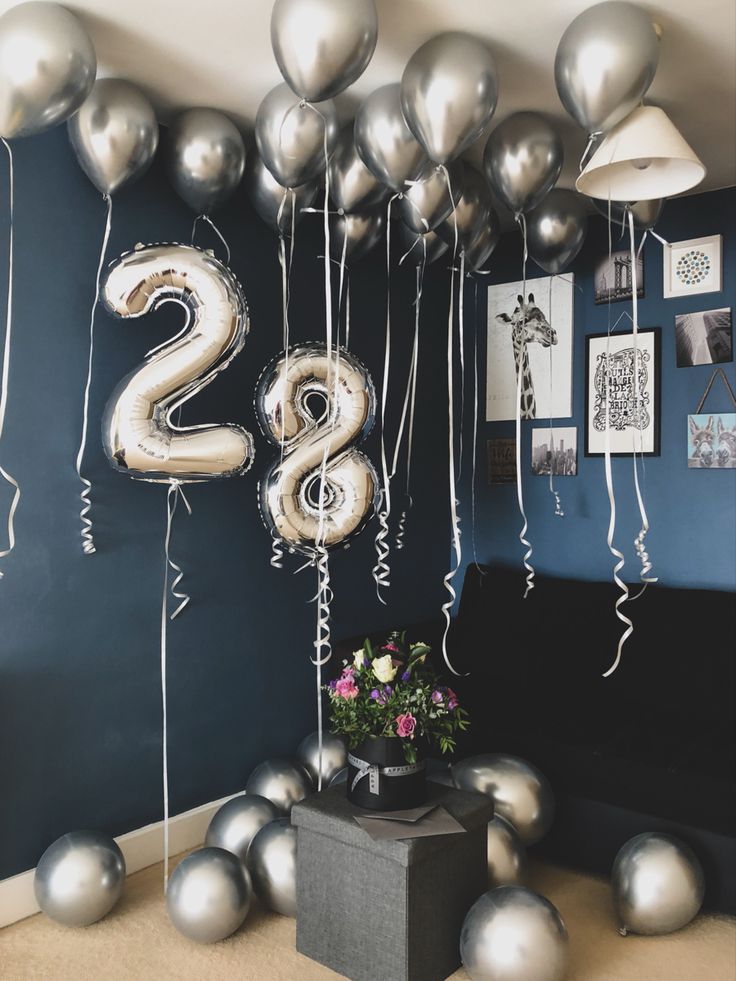 some balloons that are in the shape of numbers on a wall with pictures and flowers