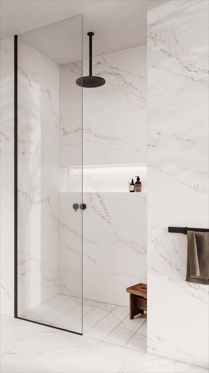 a bathroom with white marble walls and flooring, including a walk - in shower