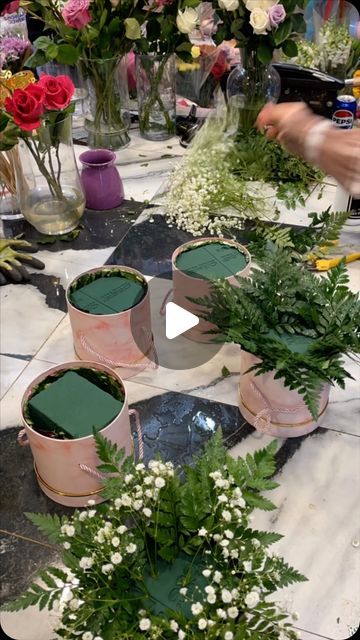 flowers are arranged in buckets on the table for making vases and flower arrangements