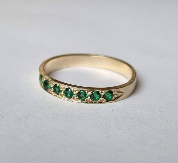 Dainty half-eternity solid gold ring set with 7 green emerald gems, stacked gemstone ring jewelry for women, available in 9k solid yellow gold, and 14k solid yellow, white, or rose gold. This delicate handmade solid gold ring is set with seven deep green emeralds. It has a vintage style design, but the green and gold combination gives it a timeless style.  Emerald is considered May's birthstone. It is available in 9k solid yellow gold and 14k solid yellow, white, or rose gold. This beautiful gol Green Half Eternity Ring In 14k Gold, 14k Gold Green Half Eternity Ring, Green 14k Gold Half Eternity Rings, 14k Gold Green Half Eternity Jewelry, Green 14k Gold Half Eternity Jewelry, 14k Gold Emerald Half Eternity Ring For May Birthstone, 14k Gold Half Eternity Emerald Ring For May Birthstone, Emerald Cut Green Stackable Rings In 14k Gold, Emerald Eternity Band In Yellow Gold As Gift