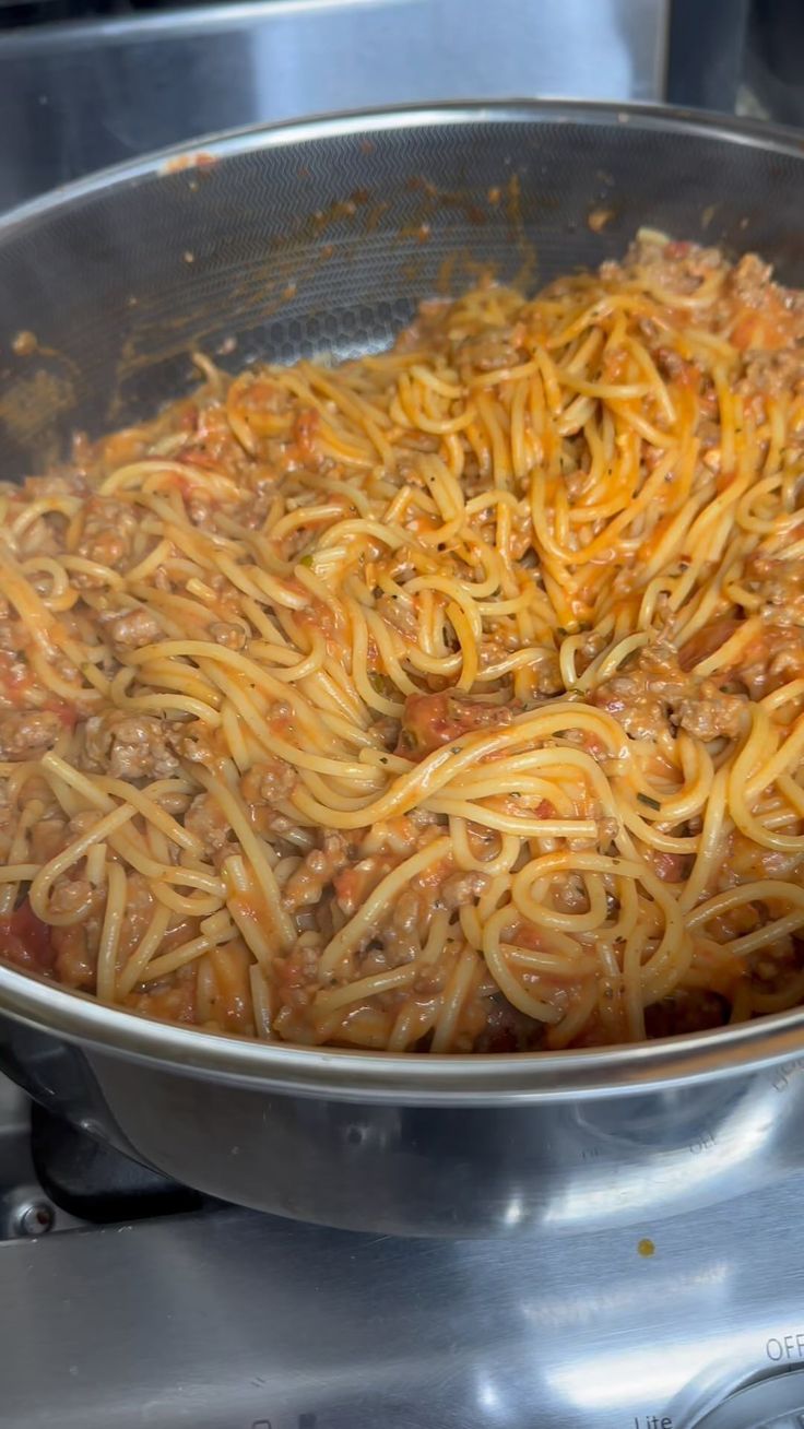 spaghetti being cooked in a pan on the stove