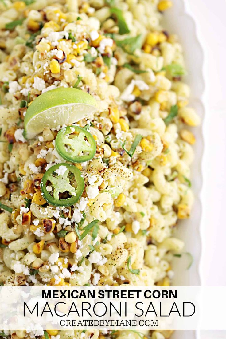 mexican street corn macaroni salad in a white serving dish with lime wedges