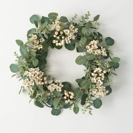 a wreath with white flowers and green leaves