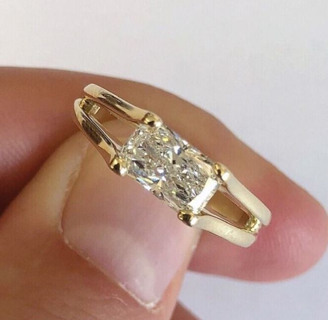 a close up of a person's hand holding an engagement ring