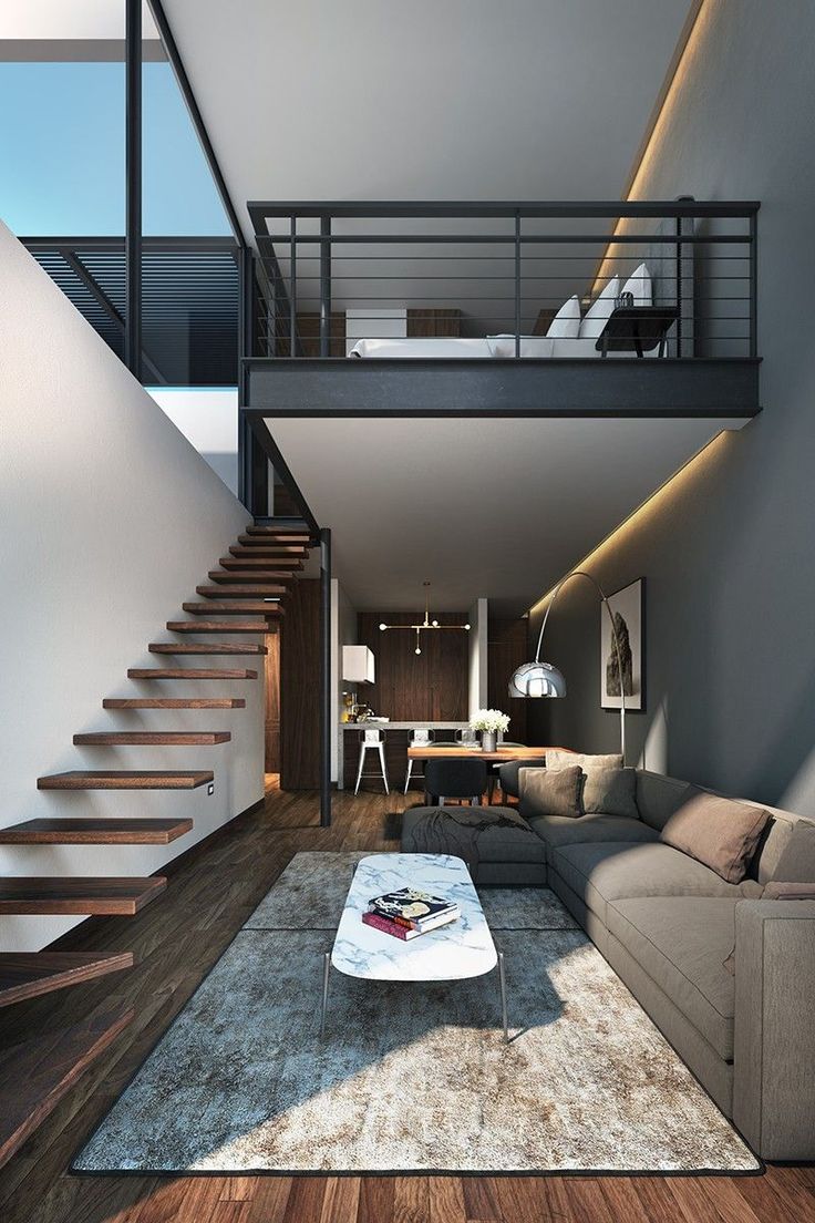 a modern living room with stairs leading up to the second floor and an area rug on the floor