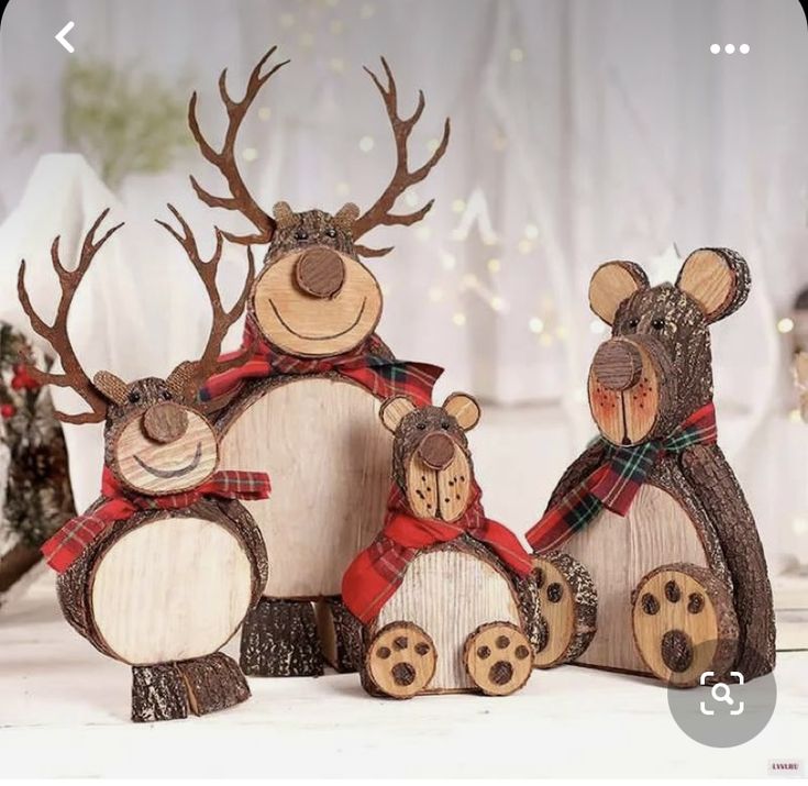 three wooden reindeer figurines sitting next to each other on top of a table