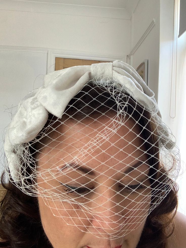 This was inspired by an original head piece I saw at a 1940s weekender. I thought it would make a beautiful adornment for a bride.  It is made of Ivory velvet on a wired base and it is secured by three small combs. one in the middle and one behind each ear. it has a small birdcage veil. It is very light a comfortable to wear and adds a retro , stylish look to any bridal outfit. These measures 18cm by 11cm. I can making this in other colours. If you would like one in a certain colour please get in touch. Please be aware that colours may differ depending on your browser and sizes are approximate Vintage Wedding Costume Hat With Pinched Crown, Vintage Wedding Hat With Pinched Crown, Vintage Evening Fascinator Headband, Vintage White Evening Fascinator, Vintage White Fascinator For Evening, Vintage Formal Headband, Vintage Formal Headband Headpiece, Vintage Evening Headband Headpiece, Vintage Headpieces For Wedding And Kentucky Derby