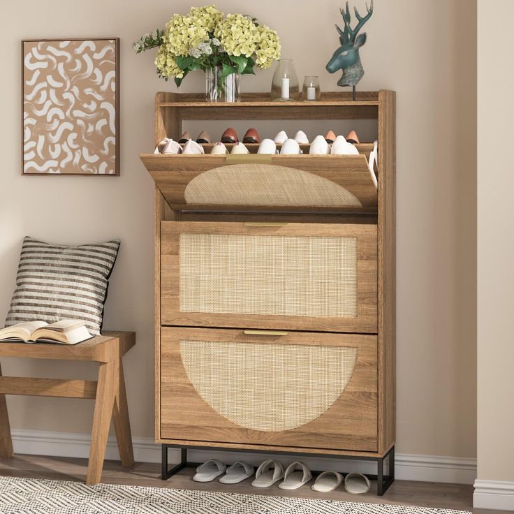 a wooden cabinet with two drawers and some shoes on it next to a chair in a living room