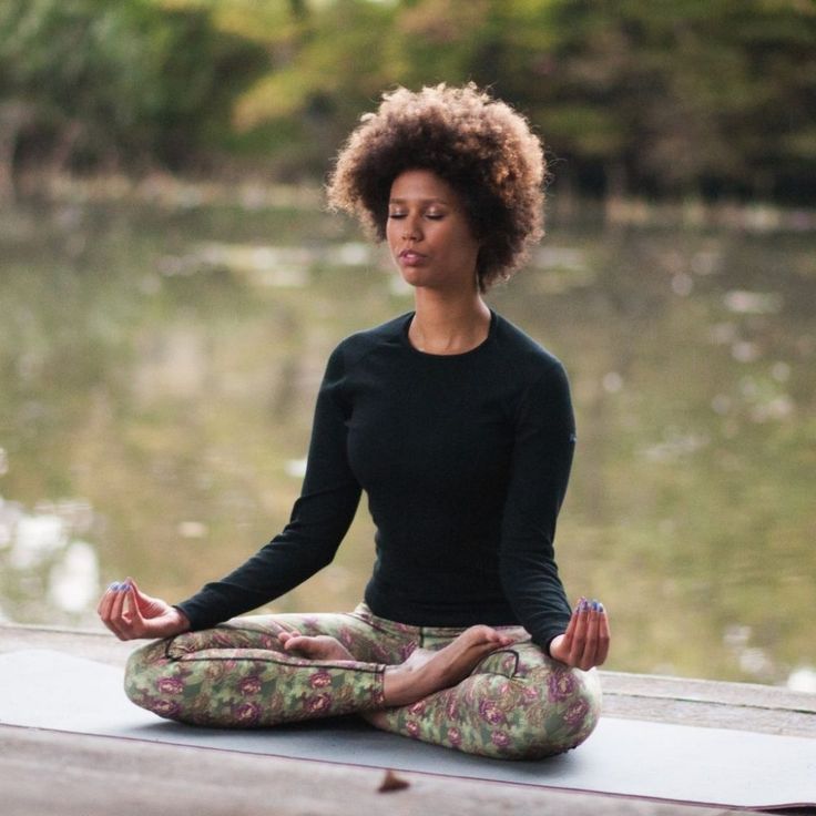 a woman sitting in the middle of a yoga pose