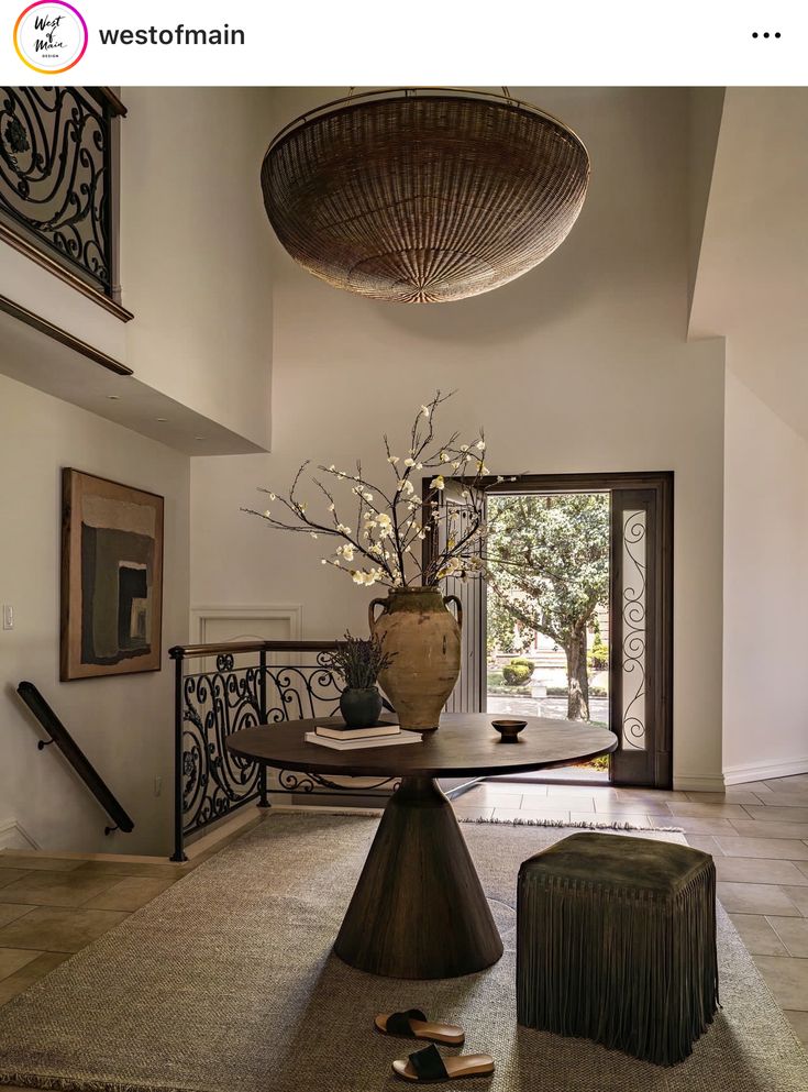 a vase with flowers is sitting on a table in the middle of a foyer area