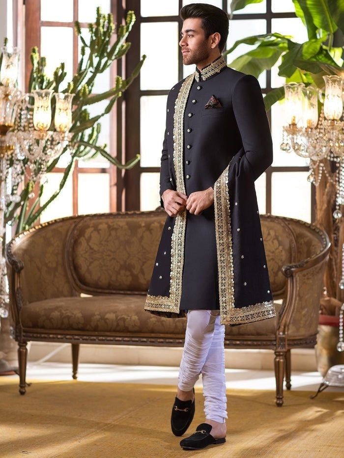 Item Contains:  Sherwani Kruta Pyjama  Shawl and Shoes  Fabrics :   Premium luxury suiting Colours :  Black base and golden dabka work White chudidaar pyjama  Style and Designs : Sherwani has mandarin collar and long sleeves with a full button placket asymmetric hem and multiple slits and it has golden hand work on neck (collar) Kurta has mandarin collar and long sleeves with a full button placket symmetric hem and multiple slits  White coloured churidar has a drawstring closure with nara Black Ceremonial Black Kurta With Naqshi Detailing, Ceremonial Black Kurta With Naqshi, Ceremonial Black Naqshi Traditional Wear, Designer Black Bandhgala With Naqshi Detailing, Designer Black Bandhgala With Naqshi, Black Naqshi Bandhgala For Festive Occasions, Formal Black Sherwani With Naqshi Detailing, Fitted Black Sherwani With Naqshi Detail, Fitted Black Sherwani With Naqshi