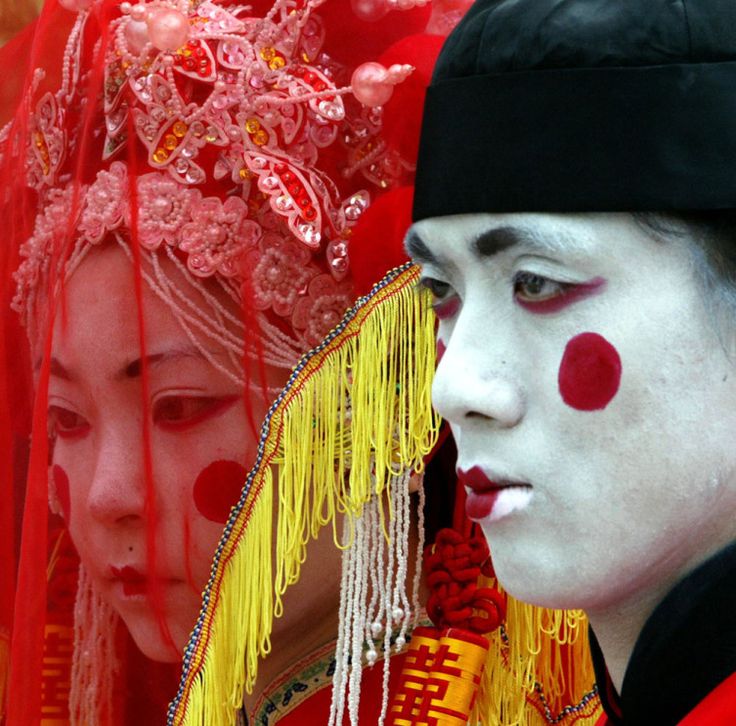 two people dressed in red and white make faces