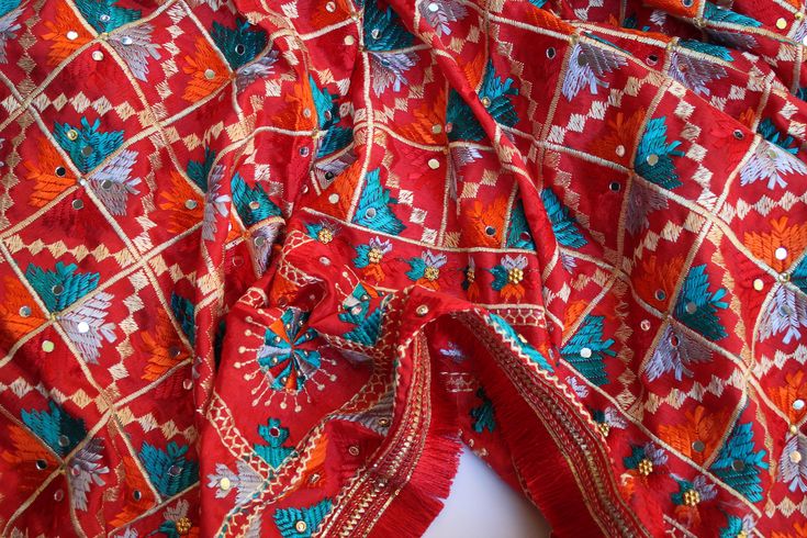 Phulkari refers to the folk embroidery of the Punjab. Although phulkari means floral work, the design include not only flowers but also covers motifs and geometrical shapes. The craft of phulkari has undergone changes over the centuries. This gorgeous colorful phulkari on pure chinnon in red color is so versatile and can be worn as a dupata, scarf or on any wedding occasion. Our phulkaris are handcrafted to perfection keeping in mind the authenticity of the culture in an urban way. Stand out with this intricately designed phulkari.  ALL SALES ARE FINAL !! Bohemian Traditional Wear With Mirror Work For Festive Season, Festive Bohemian Traditional Wear With Mirror Work, Red Bohemian Traditional Wear For Ceremonies, Festivals Rituals Resham Embroidery Dupatta, Festivals Resham Embroidery Dupatta For Rituals, Festive Cotton Dupatta With Motifs, Resham Embroidered Dupatta For Rituals And Festivals, Festive Resham Embroidery Dupatta For Rituals, Bohemian Traditional Wear For Puja And Navratri