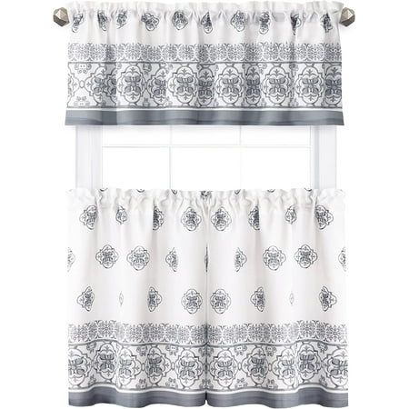 a window curtain with an ornate design on the top and bottom, hanging from a metal rod