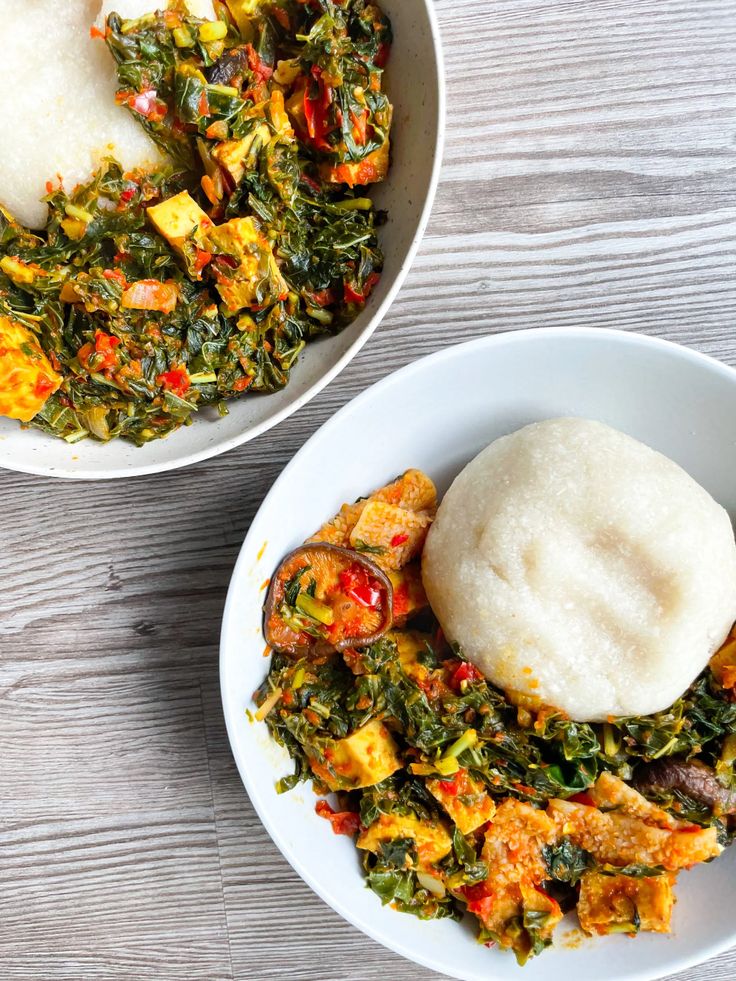 two white bowls filled with food on top of a wooden table next to each other