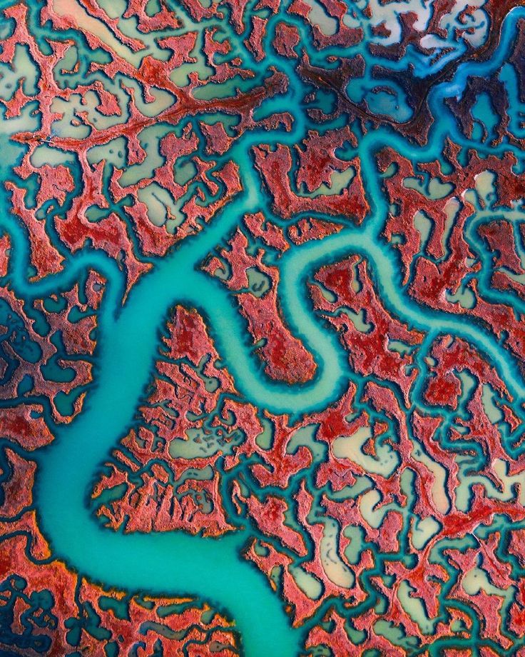 an aerial view of the water and land in this photo is blue, red and green