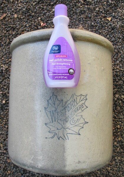 a purple bottle sitting on top of a cement container