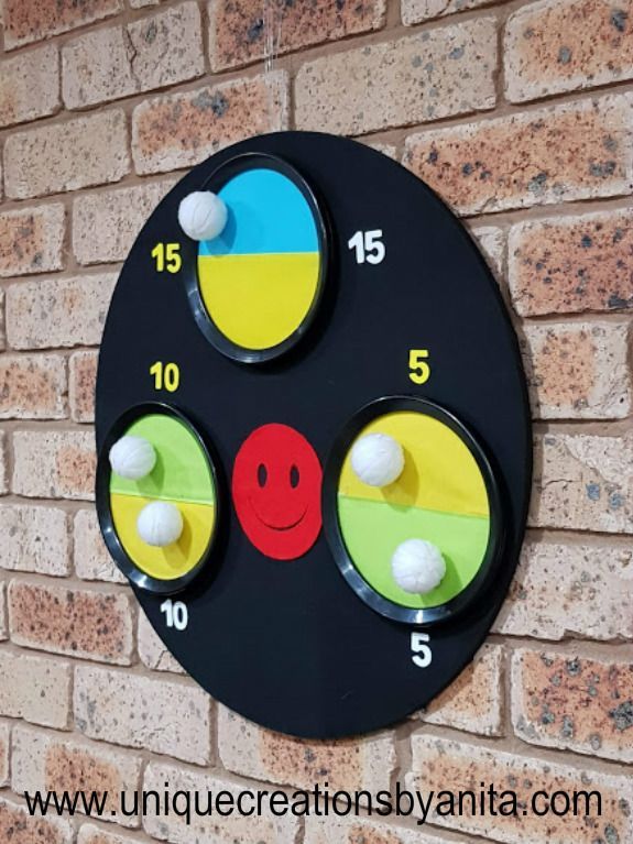 a black clock with four faces and balls on the face is mounted to a brick wall