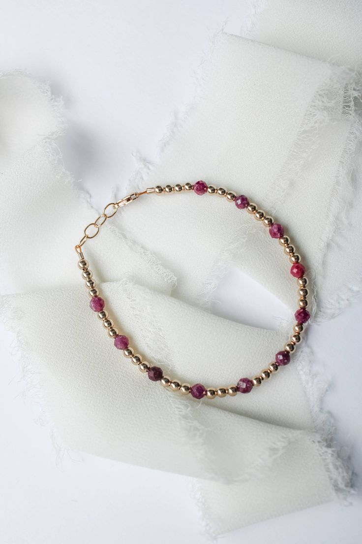 This July birthstone bracelet is crafted with genuine ruby gems, making it a perfect gift or a special treat for yourself. Stylish and elegant, the bracelet is sure to add a touch of sparkle to any outfit.  Rubys are said to promote healing and recovery. Made to last with 14k gold filled hardware. Comes in baby though adult sizes. Check out our size guide for help with sizing. We look forward to seeing you and your sweet little ones wearing your bracelets #joyfulbead. * Due to the nature of our Round Bead Birthstone Bracelets For Gifts, Round Beads Birthstone Bracelets For Gifts, Birthstone Bracelets With Round Beads For Gifts, Round Beaded Birthstone Bracelets For Gifts, Gift Birthstone Bracelets With Round Beads, Handmade Ruby Bracelets As Gifts, Dainty Adjustable Ruby Jewelry, Adjustable Dainty Ruby Jewelry, Pink Ruby Round Bracelets