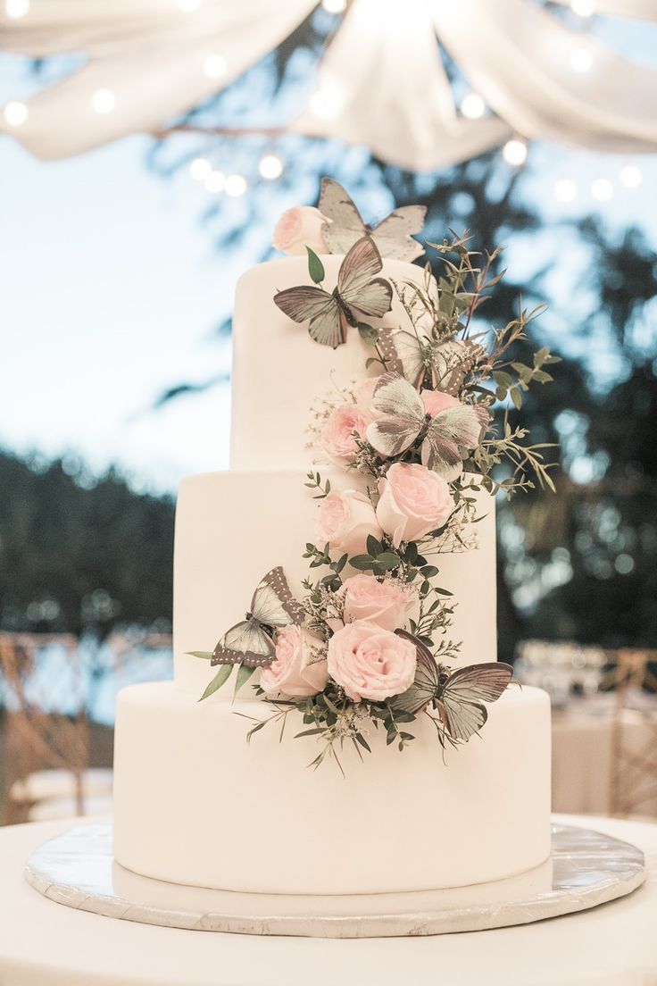 a white wedding cake with pink flowers and greenery