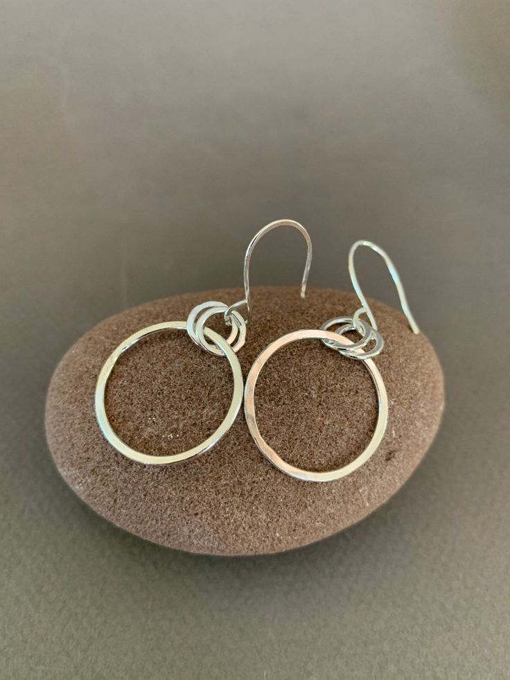 "Hand Forged Metal Jewelry | Silver Hoop Earrings, Fine Sterling Silver These round hoop earrings are perfect for everyday wear and would make a wonderful gift. We use only fine and sterling silver for all of our jewelry and findings, including our handmade earwires. Shaped and hammered for simplicity and elegance; then tumbled for strength and durability. Size is approximately 7/8\" x 1 7/8\". Our designs are each individually handcrafted and made to order.. because of this each design may have Small Hoop Sterling Silver Earrings For Pierced Ears, Simple Hoop Earrings As Gift, Simple Pierced Hoop Jewelry, Simple Dangle Hoop Earrings As Gift, Dainty Sterling Silver Hoop Jewelry, Simple Hypoallergenic Dangle Hoop Earrings, Sterling Silver Hoop Jewelry Gift, Sterling Silver Hoop Jewelry As Gift, Sterling Silver Hoop Jewelry For Gifts