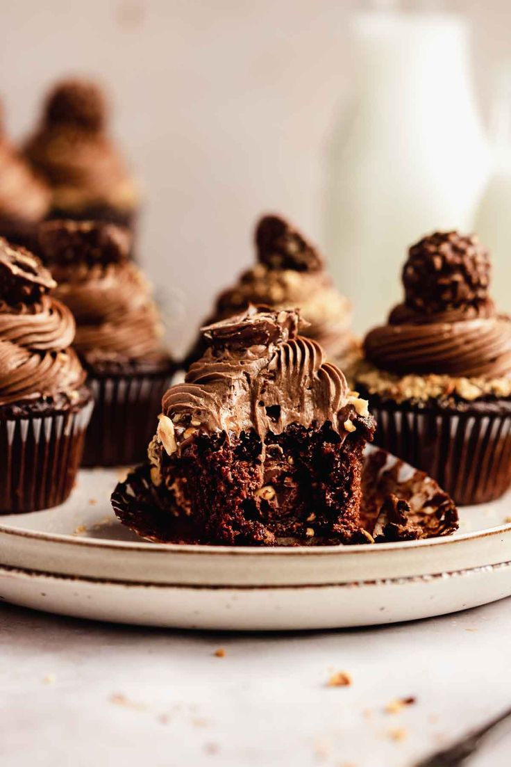 chocolate cupcakes with frosting and sprinkles on a white plate